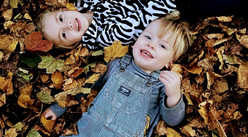two children lying in leaves