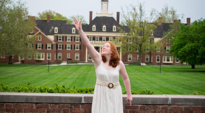 young woman tossing red graduation cap