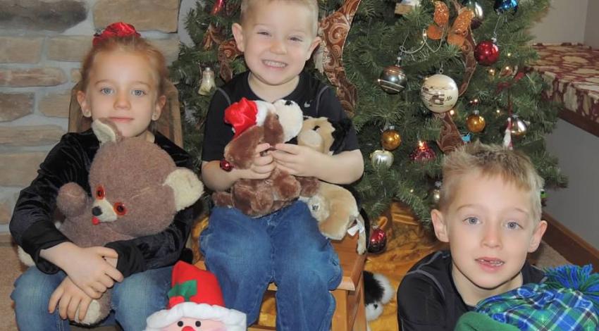 three children in front of Christmas tree