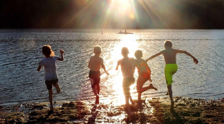 children running into lake