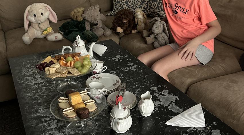 girl having tea party with stuffed animals