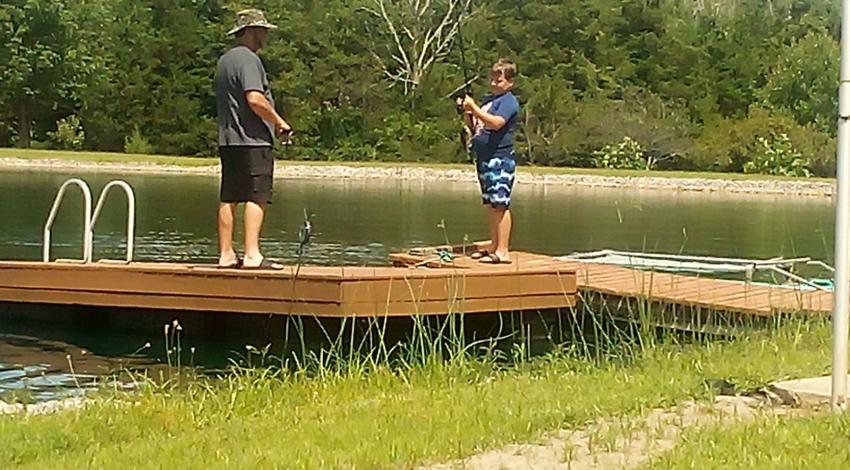 boy and man on dock with fishing gear