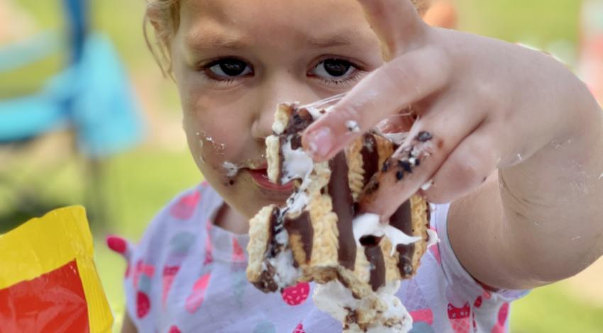 little girl holding sticky s'more