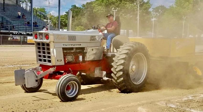man on red and silver tractor