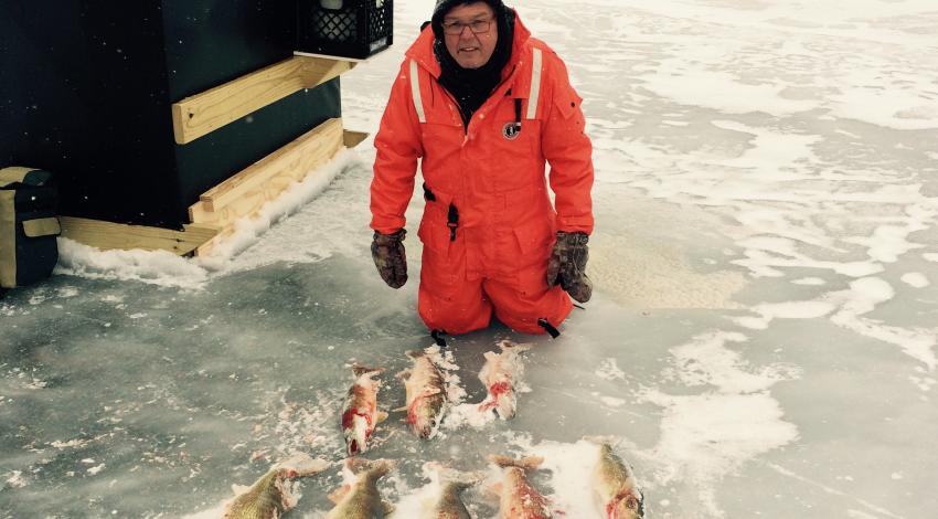 man on ice with fish