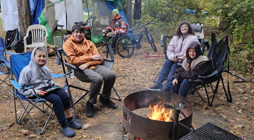 four children gathered around campfire