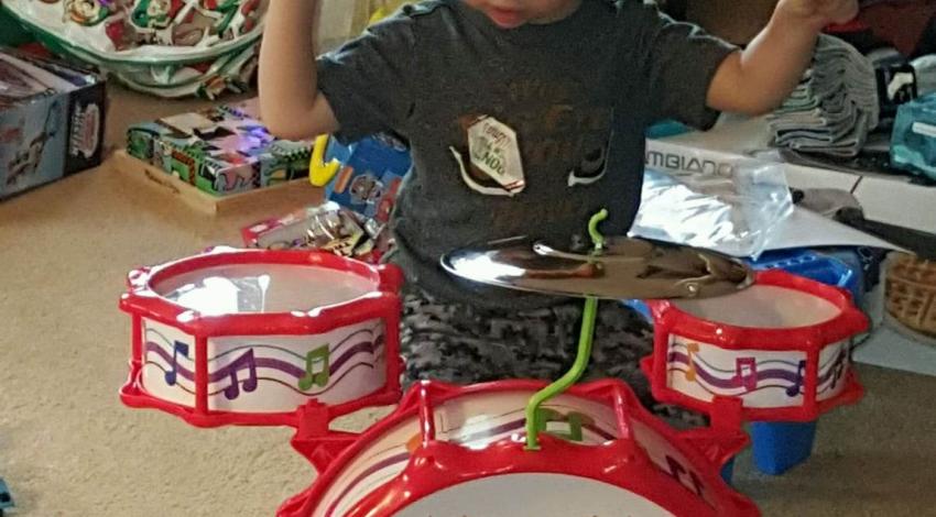 little boy at toy drum set
