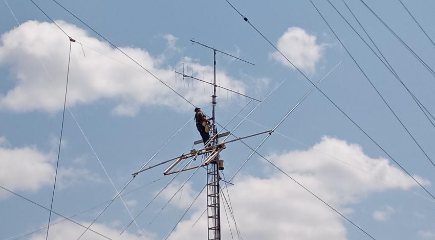 man on high tower with antenna