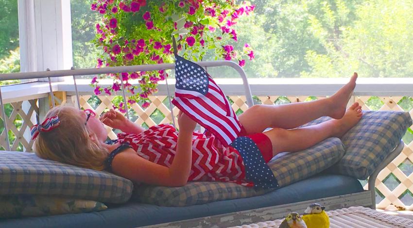 girl on porch with American flag