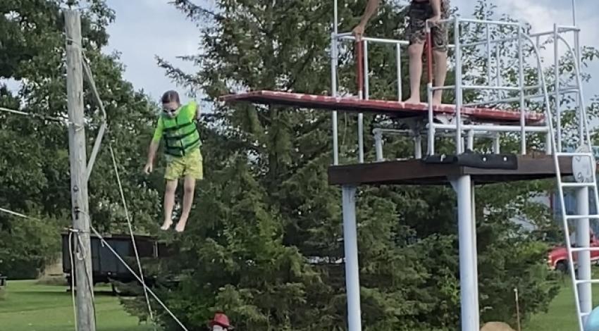 Boy jumps off high dive into lake