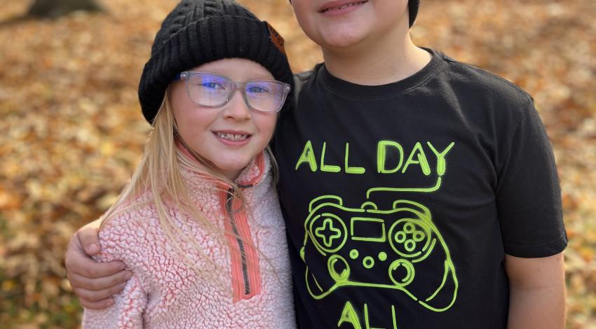 two children standing in autumn woods