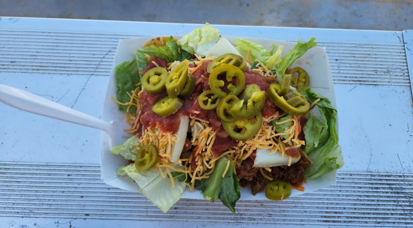 plate of nachos heaped with cheese, salsa, and jalapeños.