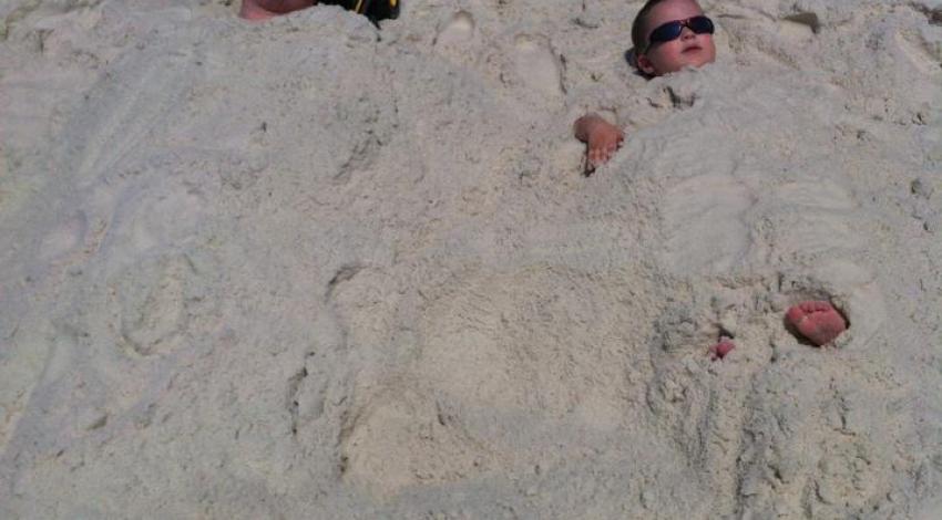 man and boy, buried in sand