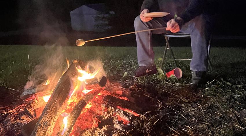 boy toasting marshmallow over a fire