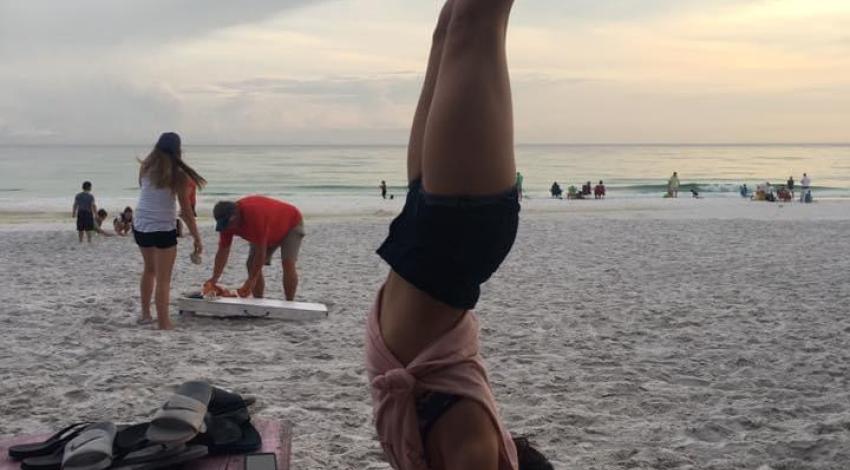 girl does handstand on picnic table bench