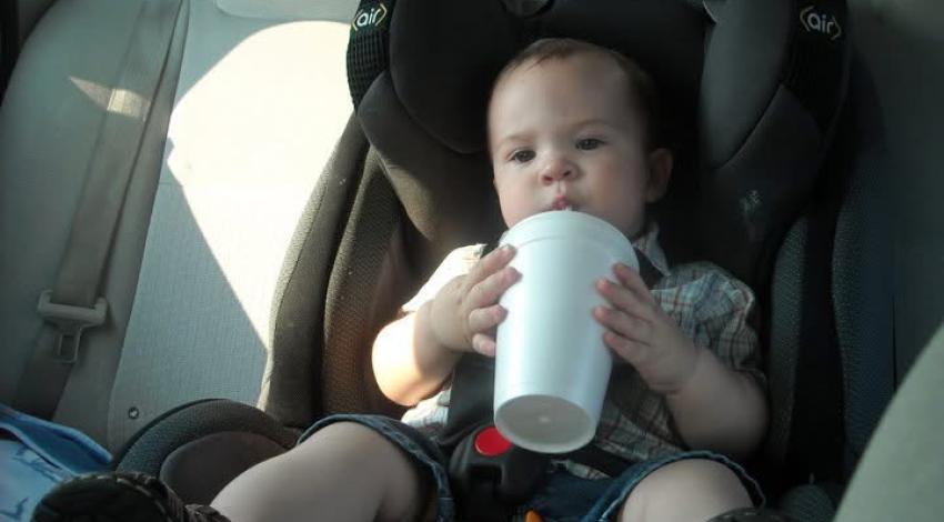 toddler in car seat drinking through straw