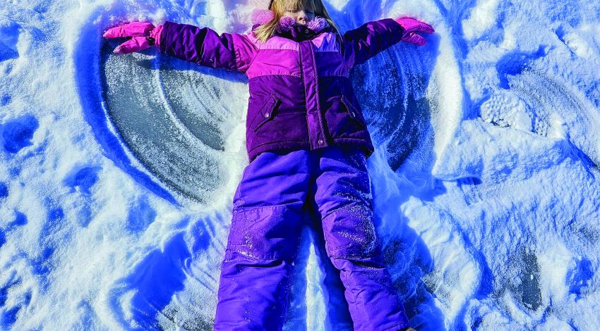 girl making snow angel