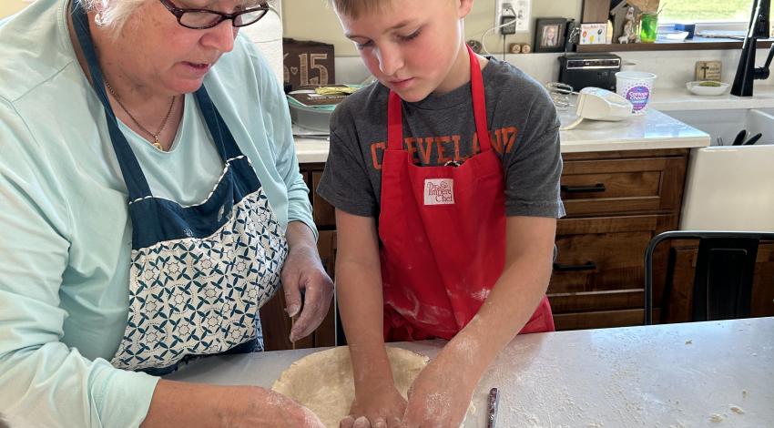 woman making pie crust with boy