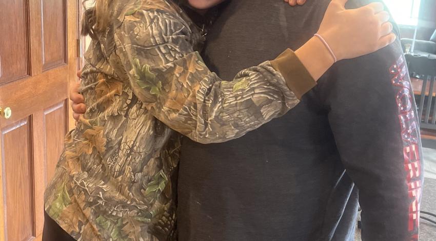 young woman hugging man