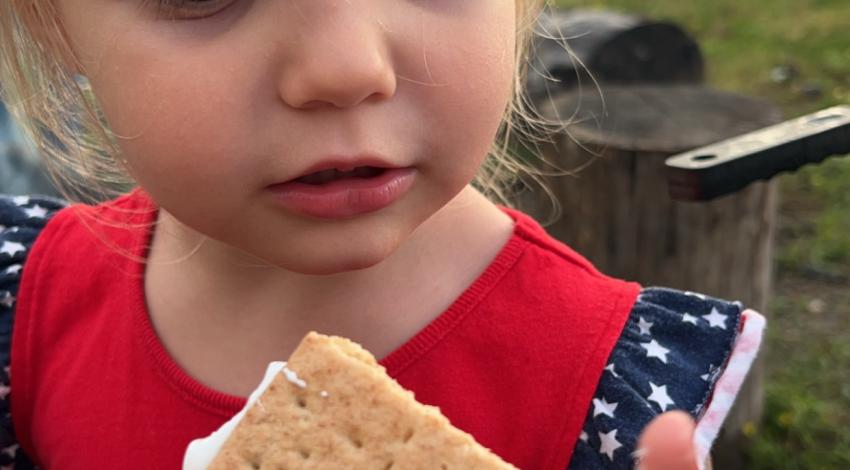 little girl holding sticky s'more