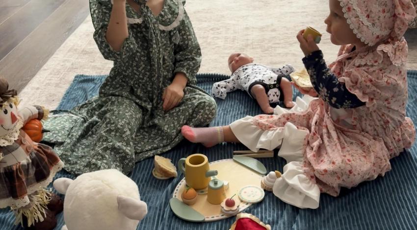 two girls having tea with toys