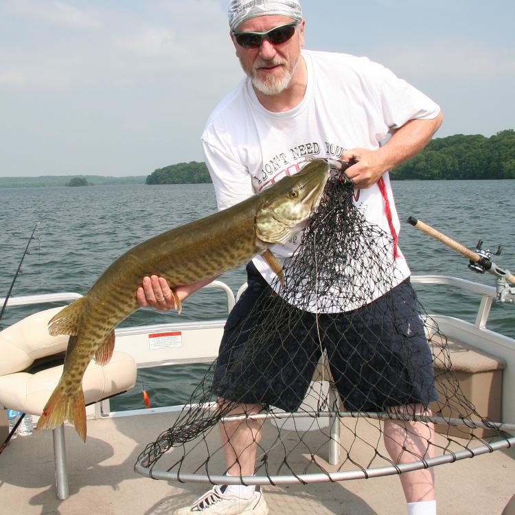 man holding fish on boat