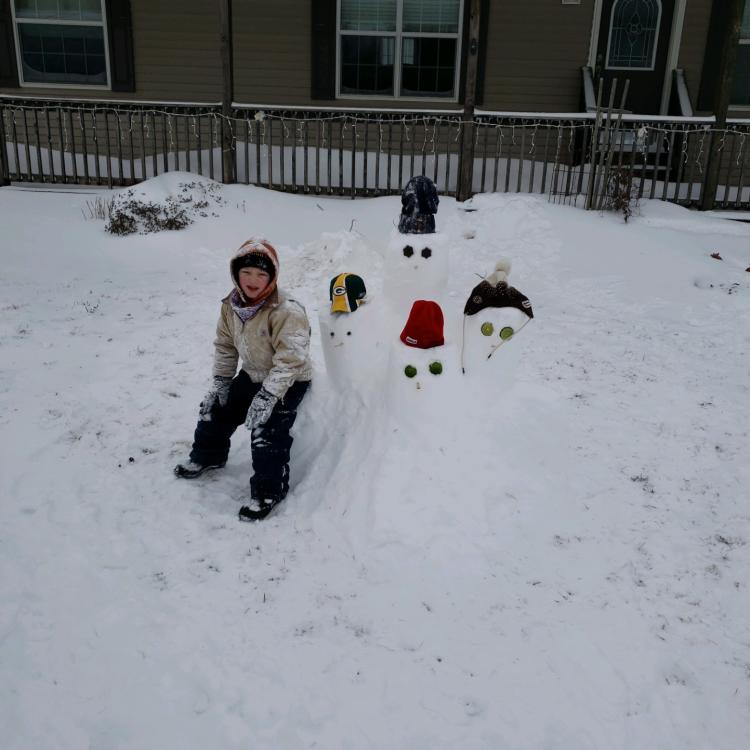 Child in the snow with snowmen