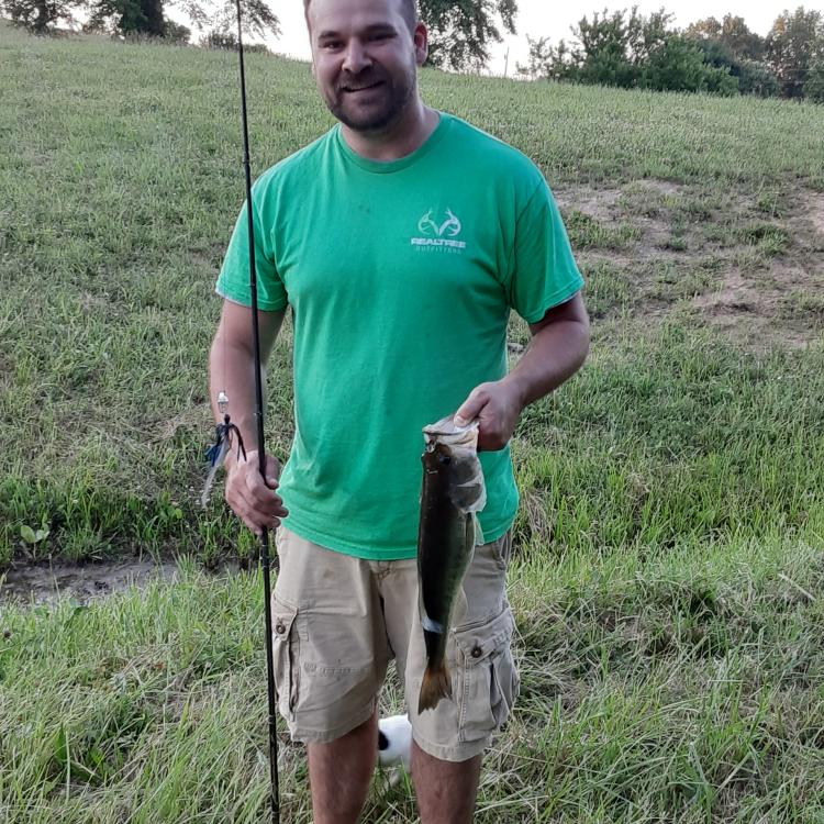 man smiling holding a fish