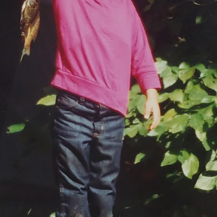 Boy proudly holds a fish