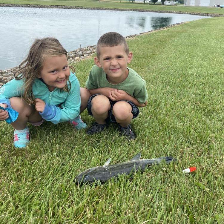 two children smiling with their fish