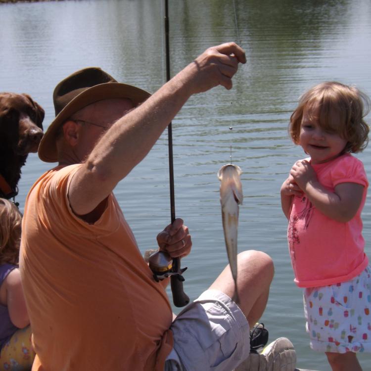 man teaching kids to fish