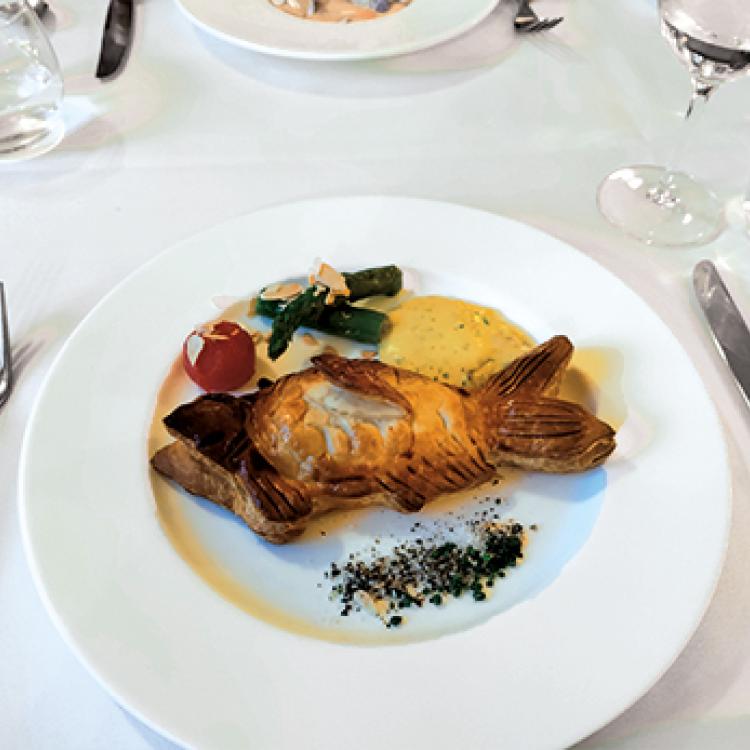 fancy dinner plate on white-clothed table