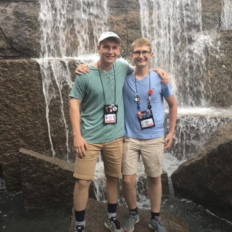 Two teen boys in front of a waterfall