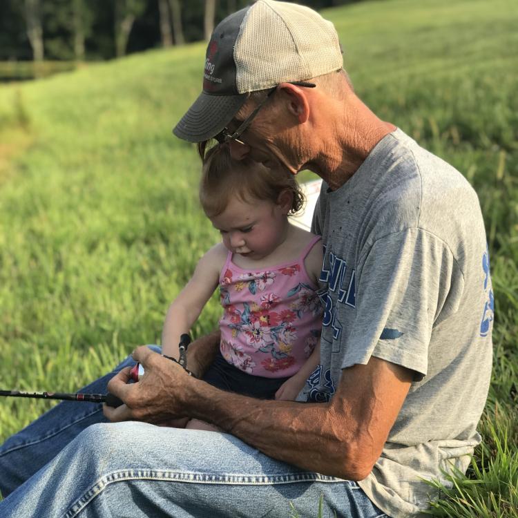 little girl fishing with her grandpa