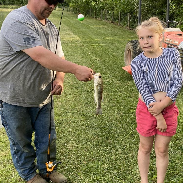 girl standing next to her first fish