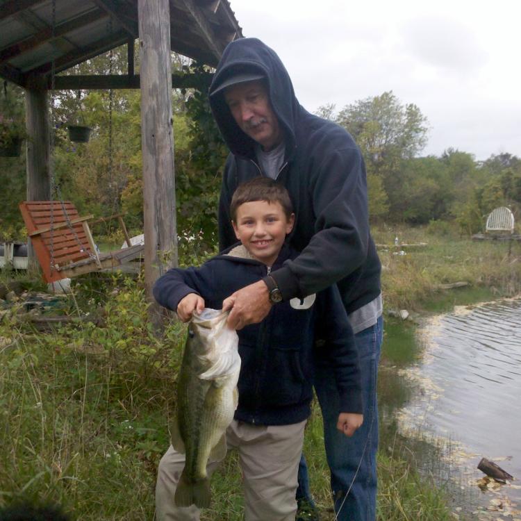 boy smiling while holding a fish