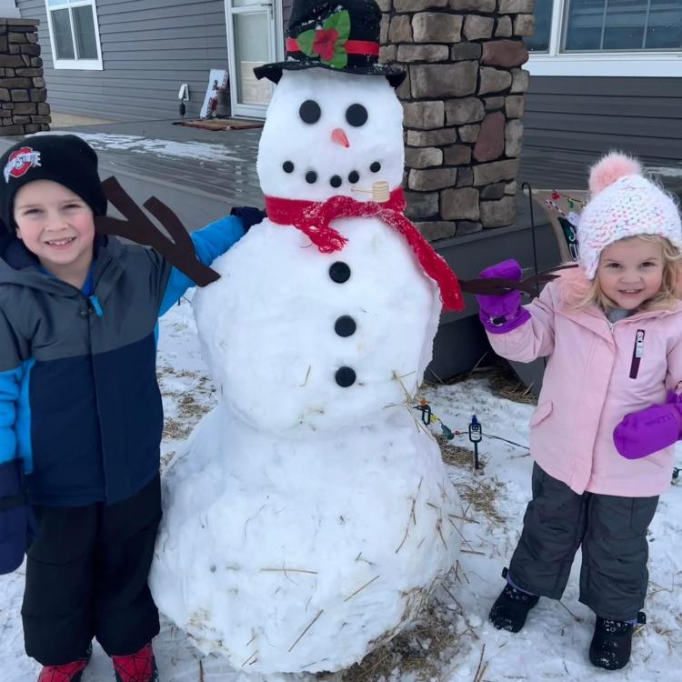 two children next to a snowman