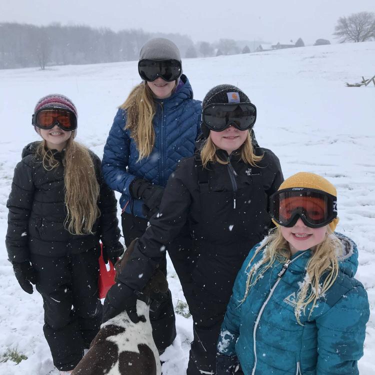 Three girls and a dog in the snow