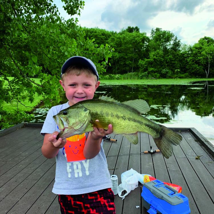 boy smiling holding a fish