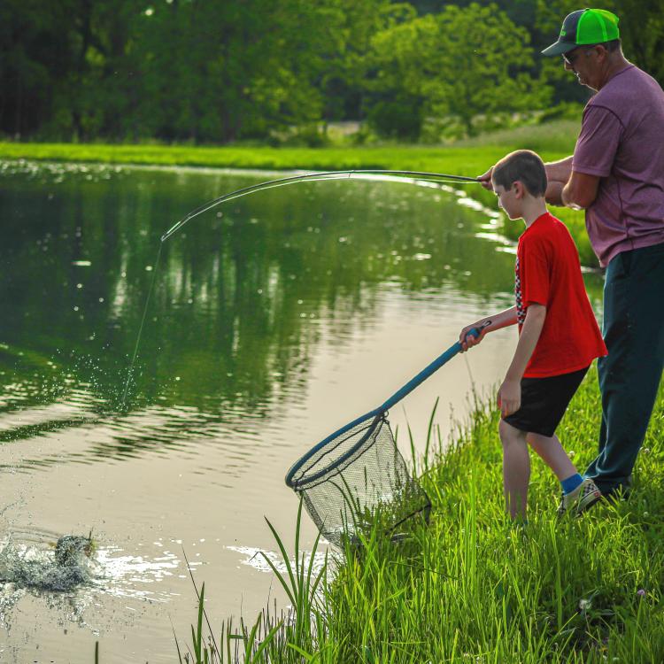 boy fishing with his grandpa