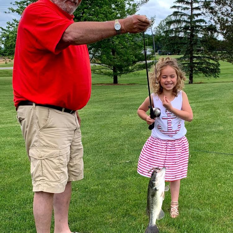 Little girl smiling at a fish