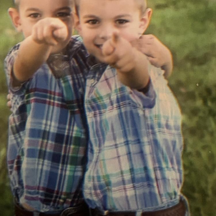 two little boys next to each other, pointing forward
