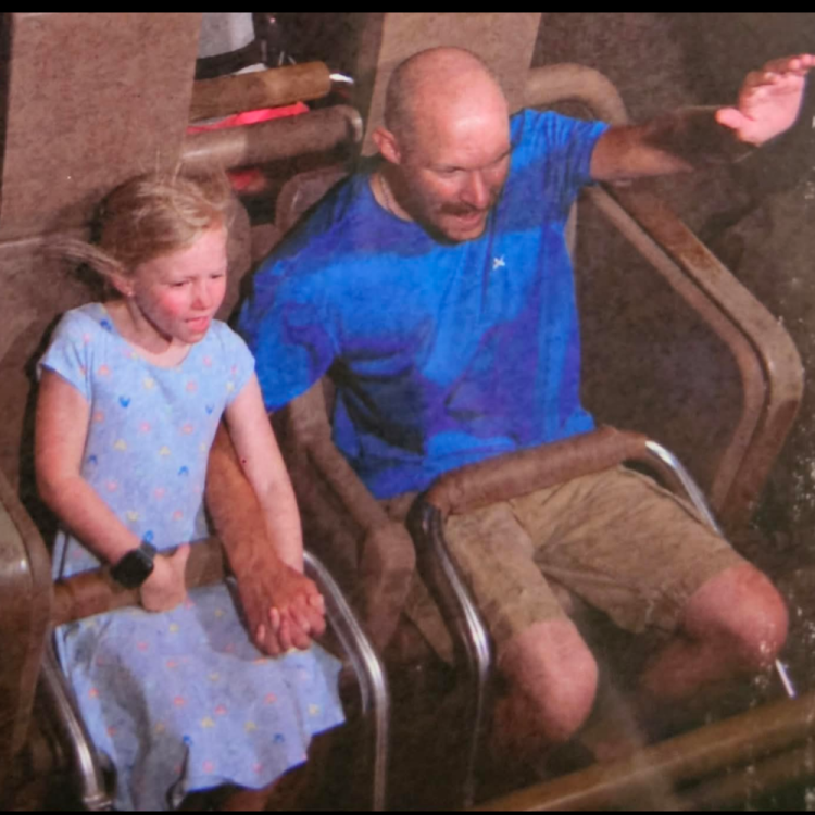 man and girl holding hands on roller coaster