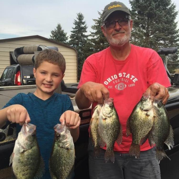 man and boy holding fish