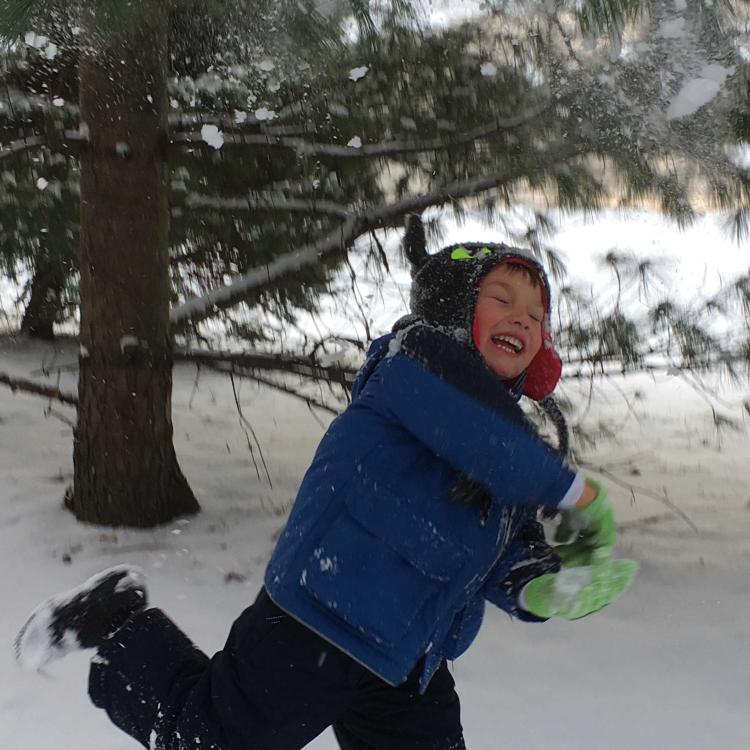 smiling boy running in the snow