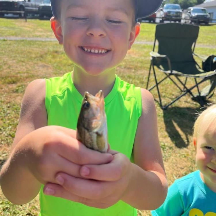 boy smiling holding a fish