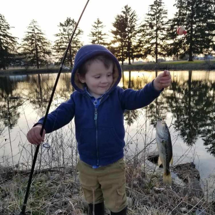 boy smiling holding a fish