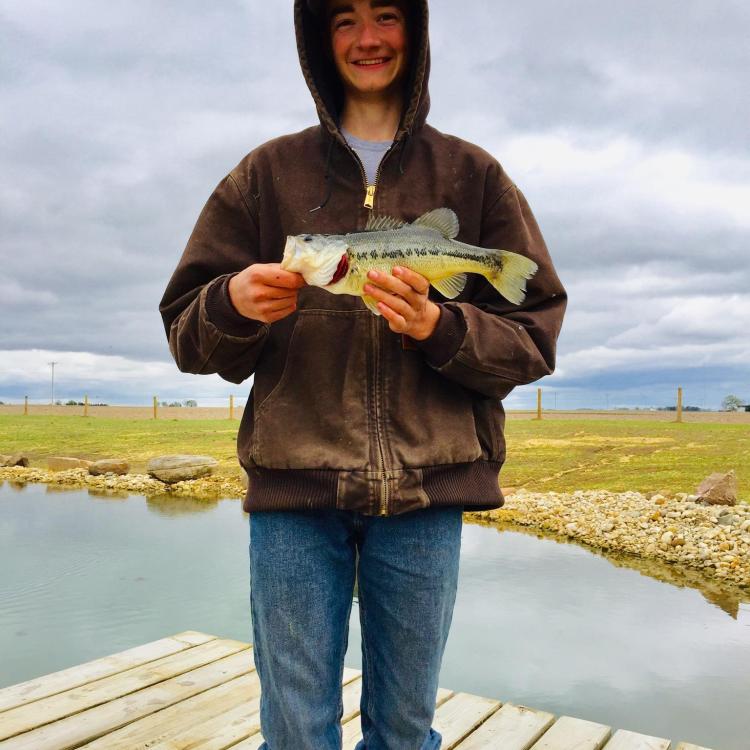 boy smiling while holding a fish