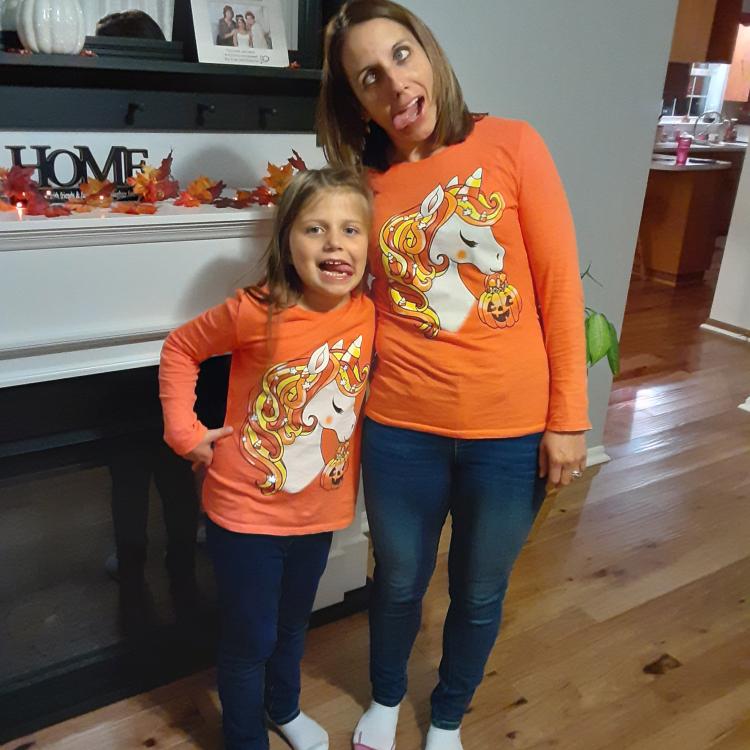 woman and girl in orange shirts, making funny faces