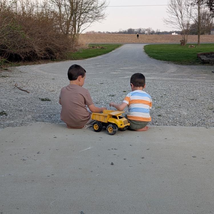 two boys playing with toy truck